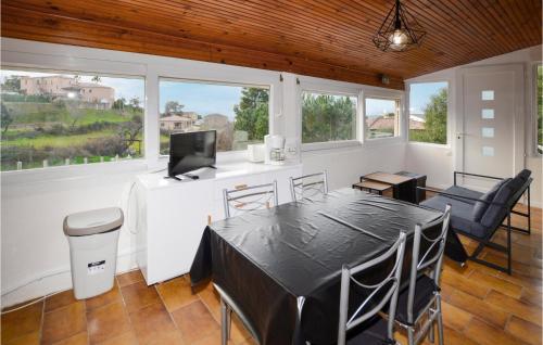 une salle à manger avec une table, des chaises et des fenêtres dans l'établissement Pet Friendly Apartment In Bastelicaccia, à Bastelicaccia