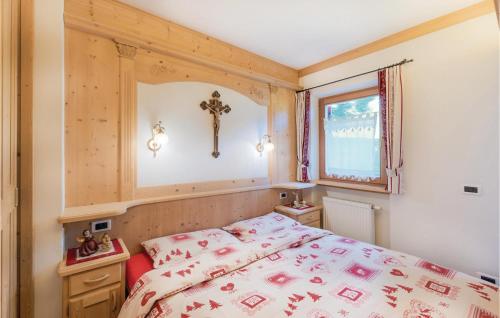 a bedroom with a bed and a cross on the wall at Residence Alessandra in Corvara in Badia