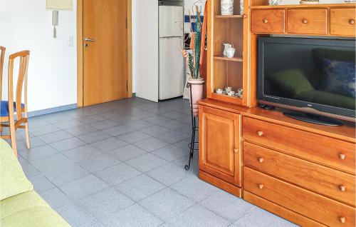a living room with a television on a wooden entertainment center at Amazing Apartment In Oropesa Del Mar in Oropesa del Mar