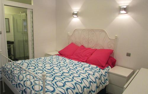 une chambre avec un grand lit avec des oreillers rouges dans l'établissement 2 Bedroom Awesome Apartment In Algajola, à Algajola