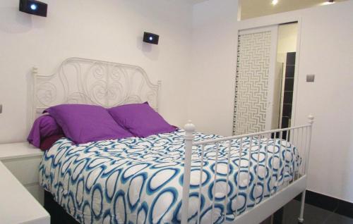 a white bed with purple pillows in a room at Awesome Apartment In Algajola With 2 Bedrooms in Algajola