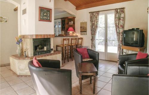 un salon avec des chaises et une cheminée dans l'établissement Three-Bedroom Holiday Home In La Tranche Sur Mer, à La Tranche-sur-Mer