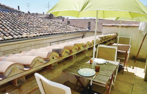 une table avec un parasol sur le toit dans l'établissement Lovely Home In Beaucaire With Wifi, à Beaucaire