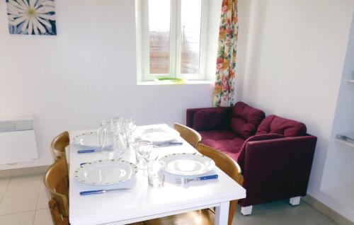 une salle à manger avec une table blanche et un canapé dans l'établissement Holiday Home Acqueville - Les Pavillons O-795, à Deux-Jumeaux