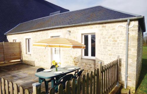 une table avec un parasol devant un bâtiment dans l'établissement Holiday Home Acqueville - Les Pavillons O-795, à Deux-Jumeaux