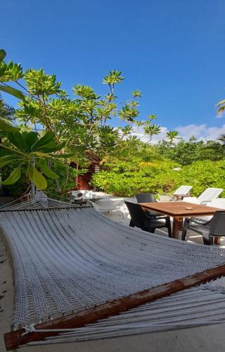 a hammock on a beach with a table and chairs at Beach Cottage in Rasdu
