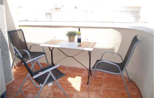 a table with two chairs and a bottle of wine at 2 Bedroom Cozy Apartment In Torrevieja in Torrevieja