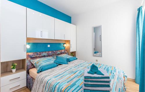 a bedroom with a large bed with a blue headboard at Stunning Apartment In Crikvenica With Kitchen in Crikvenica