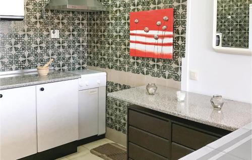 a kitchen with a red towel hanging on the wall at Beautiful Apartment In Roquetas De Mar With 2 Bedrooms, Wifi And Outdoor Swimming Pool in Roquetas de Mar