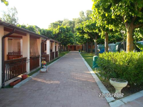 a brick sidewalk next to a house with trees at Villaggio Costa d'Argento in San Vito Chietino