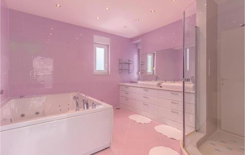 a purple bathroom with a tub and two sinks and a shower at Cozy Home In Crikvenica With Wifi in Crikvenica