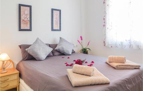 Una cama con dos almohadas y flores. en Urb Altos Bahia Vii, en Torrevieja