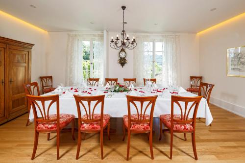 a dining room with a white table and chairs at Hotel Landgasthof Schönbühl in Schönbühl