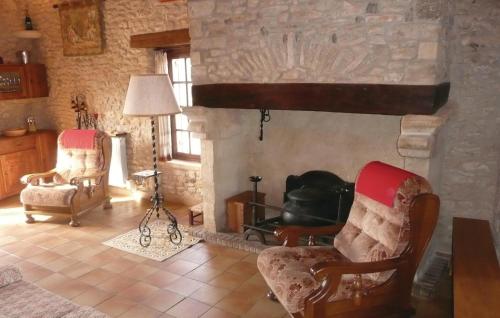 a living room with two chairs and a fireplace at Beautiful Home In Val-de-louvre-et-caude With 3 Bedrooms in Saint-Alvère