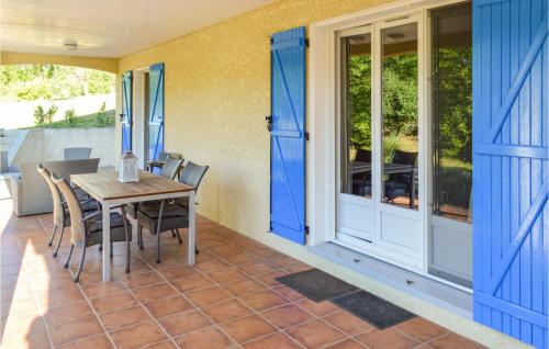 d'une terrasse avec des portes bleues, une table et des chaises. dans l'établissement Lovely Home In Le Poujol Sur Orb, à Le Poujol-sur-Orb