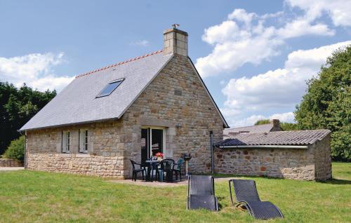 une maison en pierre avec une table et des chaises devant elle dans l'établissement 1 Bedroom Gorgeous Home In Tregunc, à Trégunc