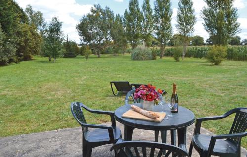 a table with a bottle of wine and flowers on it at 1 Bedroom Gorgeous Home In Tregunc in Trégunc