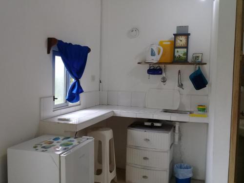 małą kuchnię ze zlewem i oknem w obiekcie Portón Azul w mieście Montañita