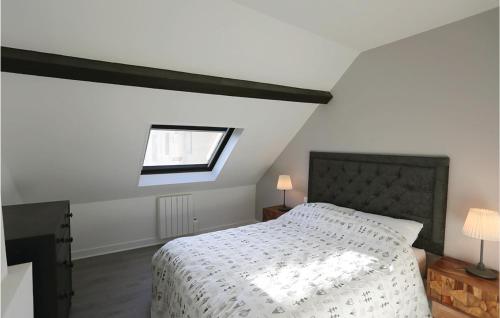 um quarto com uma cama com um edredão branco e uma janela em 3 Bedroom Awesome Home In Jaulgonne em Jaulgonne