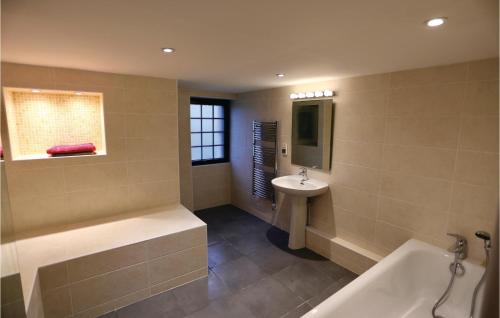 uma casa de banho com uma banheira e um lavatório em 3 Bedroom Awesome Home In Jaulgonne em Jaulgonne