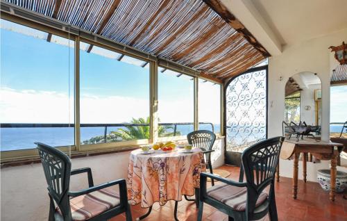 a dining room with a table and chairs and windows at Awesome Home In Roquebrune-Sur-Argens in Saint-Peïre-sur-Mer