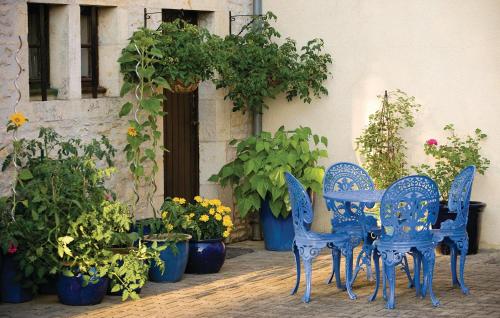 un groupe de chaises bleues et de plantes en pot dans l'établissement Awesome Home In Gabillou With Wifi, à Gabillou