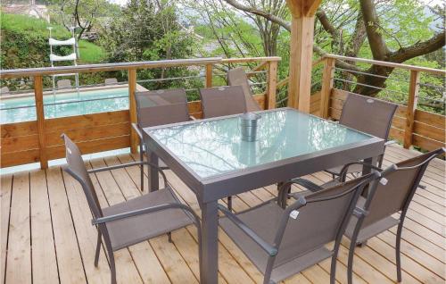a glass table and chairs on a deck with a pool at Beautiful Home In Bordezac in Bordezac