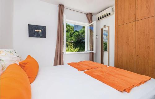 sypialnia z łóżkiem z pomarańczowym kocem w obiekcie Awesome Apartment In Banjol With Kitchen w mieście Banjol
