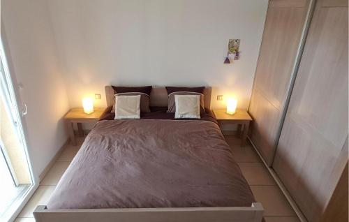 a bed in a room with two lamps on two tables at 3 Bedroom Nice Home In Quarante in Quarante