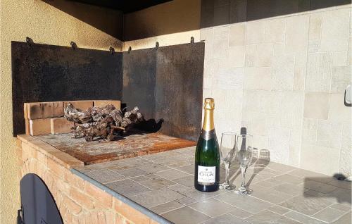 a bottle of wine sitting on a counter with wine glasses at 3 Bedroom Nice Home In Quarante in Quarante