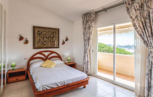 um quarto com uma cama e uma grande janela em Pet Friendly Home In Sant Feliu De Guxols With Kitchen em Sant Feliu de Guixols