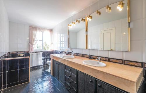 a bathroom with two sinks and a large mirror at Pet Friendly Home In Sant Feliu De Guxols With Kitchen in Sant Feliu de Guixols