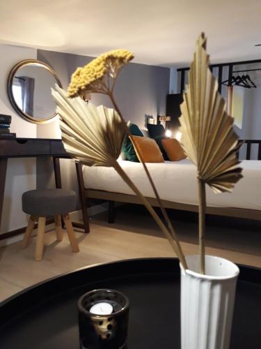 a vase with a plant on a table in a bedroom at La Mar de Ben in Muros