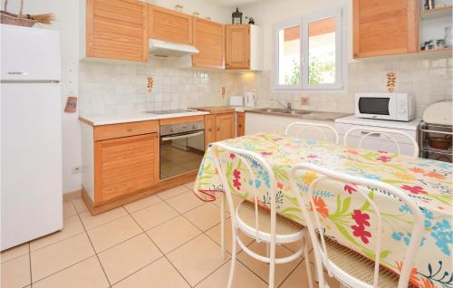 une cuisine avec une table, des chaises et un réfrigérateur dans l'établissement Holiday Home Pignan Gh-1268, à Pignan