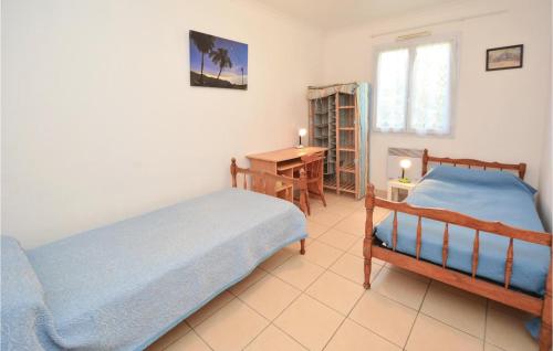 - une chambre avec 2 lits, une table et un bureau dans l'établissement Beautiful Home In Pignan With 3 Bedrooms, à Pignan