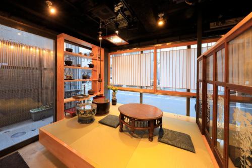 Cette chambre comprend une table et un tabouret. dans l'établissement Andon Ryokan, à Tokyo