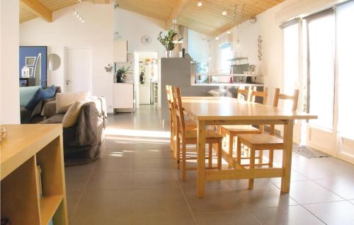 a kitchen and living room with a wooden table and chairs at Three-Bedroom Holiday Home In St Michel En L'herm in Saint-Michel-en-lʼHerm