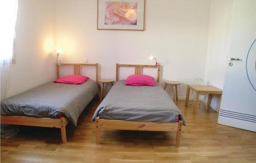 - 2 lits dans une chambre avec 2 oreillers roses dans l'établissement 3 Bedroom Stunning Home In St, Michel En Lherm, à Saint-Michel-en-lʼHerm