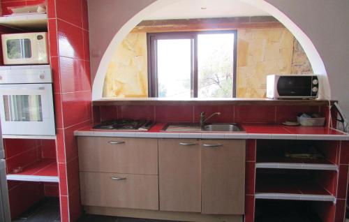 a kitchen with a sink and an arched window at Stunning Apartment In Partinello With 3 Bedrooms And Wifi in Partinello