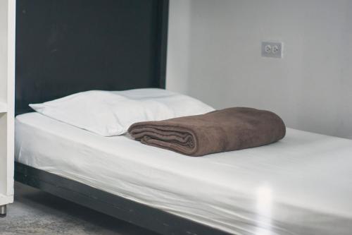 Una toalla marrón sobre una cama en Casa Estación Hostal y Restaurante, en Medellín