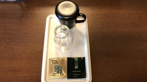 a white tray with a bottle and a bottle at Hotel Route-Inn Nobeoka Ekimae in Nobeoka