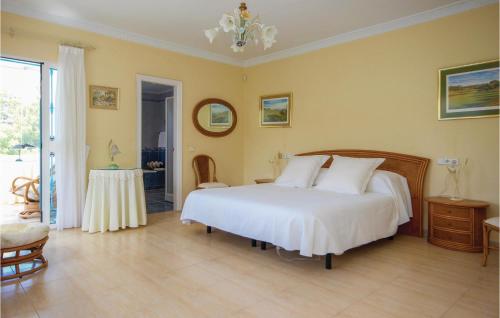 1 dormitorio con cama blanca y mesa en Nice Apartment In Urb El Chaparral With Swimming Pool, en Mijas Costa