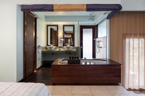 baño con bañera grande y lavamanos en Fisherman's Cove Resort, en Bel Ombre