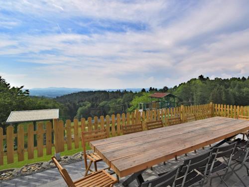 einem Holztisch mit Stühlen und einem Holzzaun in der Unterkunft Holiday home with panoramic view and every convenience spa in Waldkirchen