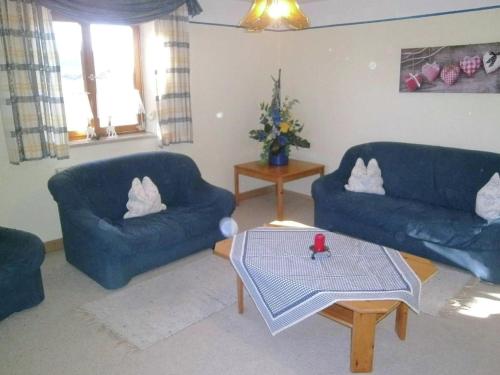 ein Wohnzimmer mit 2 blauen Sofas und einem Tisch in der Unterkunft Cosy Holiday Home in Feldwies near Ski Area in Übersee
