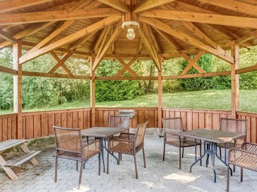 a wooden pavilion with tables and chairs on a patio at Apartment with large communal terrace in Wünschendorf