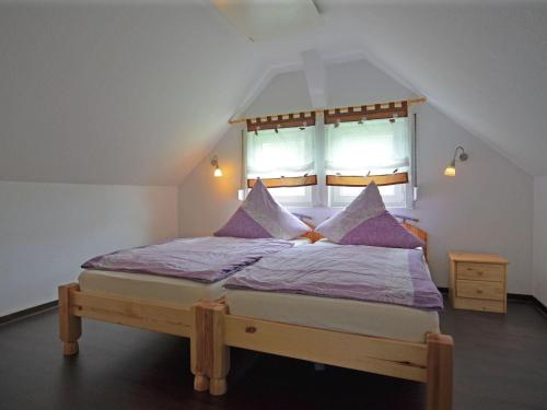 ein Schlafzimmer mit einem Bett mit violetter Bettwäsche und einem Fenster in der Unterkunft Spacious holiday home in Sauerland with terrace in Glashütte
