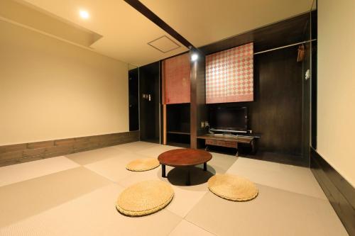 a room with two stools and a table and a television at Andon Ryokan in Tokyo
