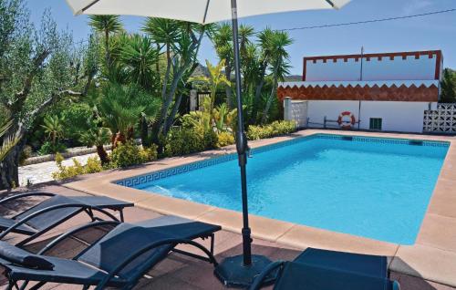 a swimming pool with chairs and an umbrella at Lovely Home In Alcúdia in Alcudia