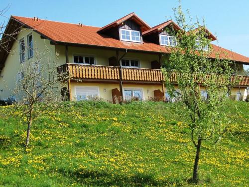 a house on a hill with a field of flowers at Wohnung in Rotthalmünster mit Garten in Rotthalmünster